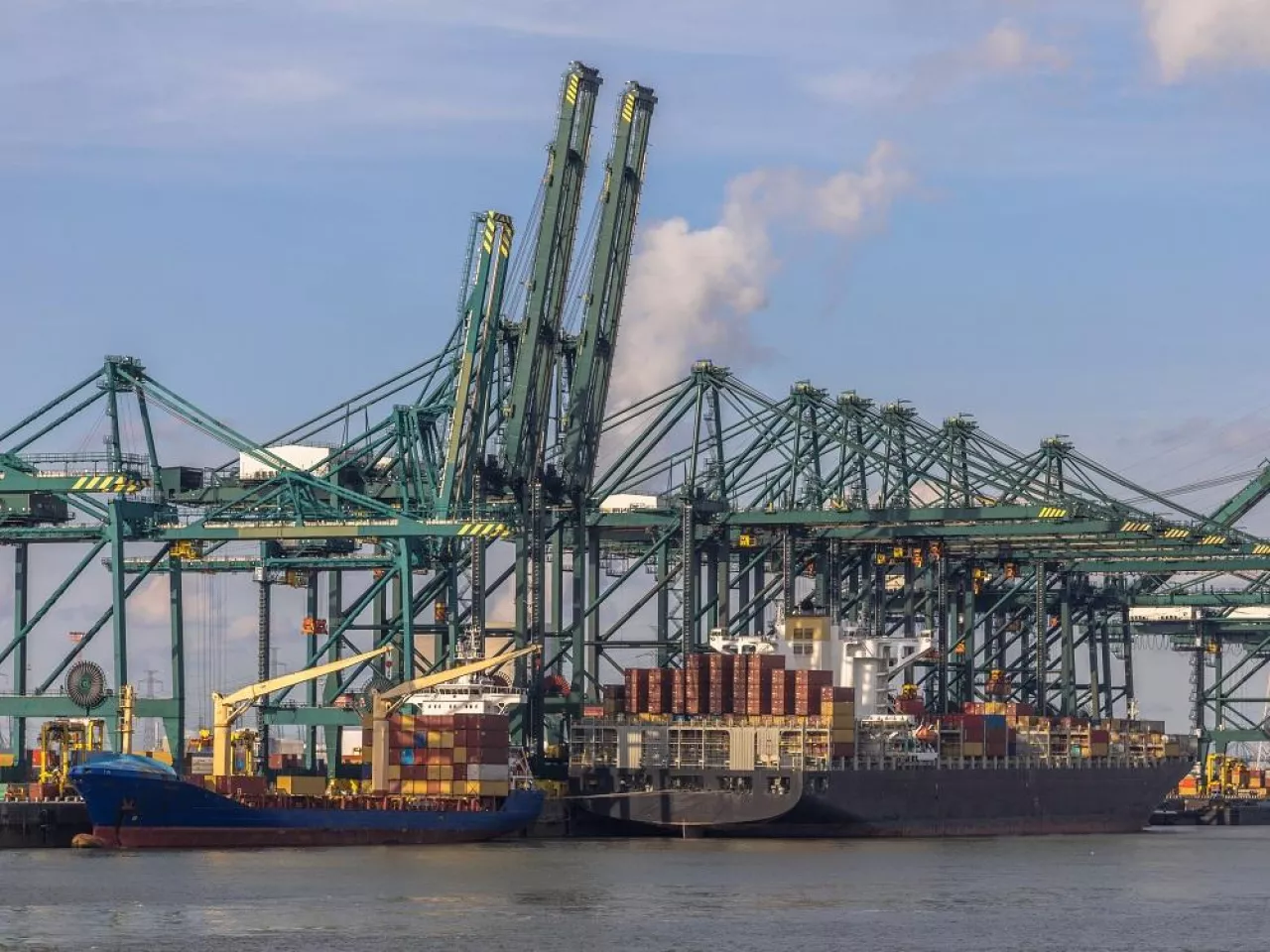 Loading of ships in busy port of Antwerp at container terminal with automated cranes and lots of vessels. Belgium