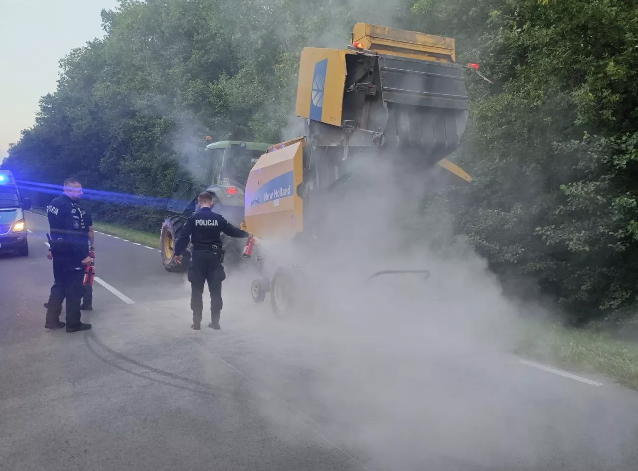 Policjanci gaśnicami gaszą prasę rolniczą
