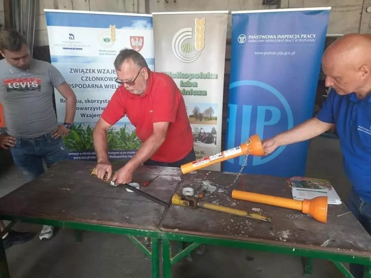 Mężczyźni wymieniają osłony WOM ciągnika rolniczego