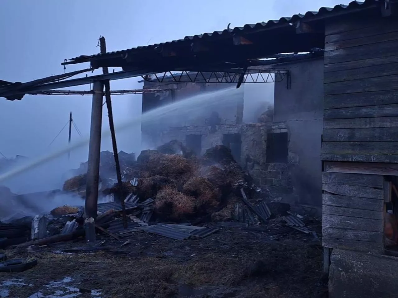 Strażacy gaszą budynek gospodarczy