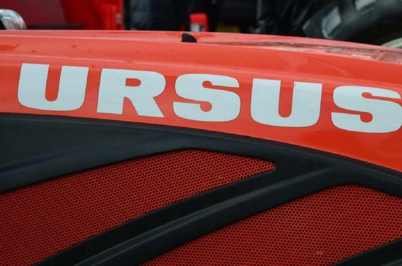 Zbliżenie na maskę ciągnika Ursus – widoczne logo marki na czerwonej obudowie maszyny rolniczej.