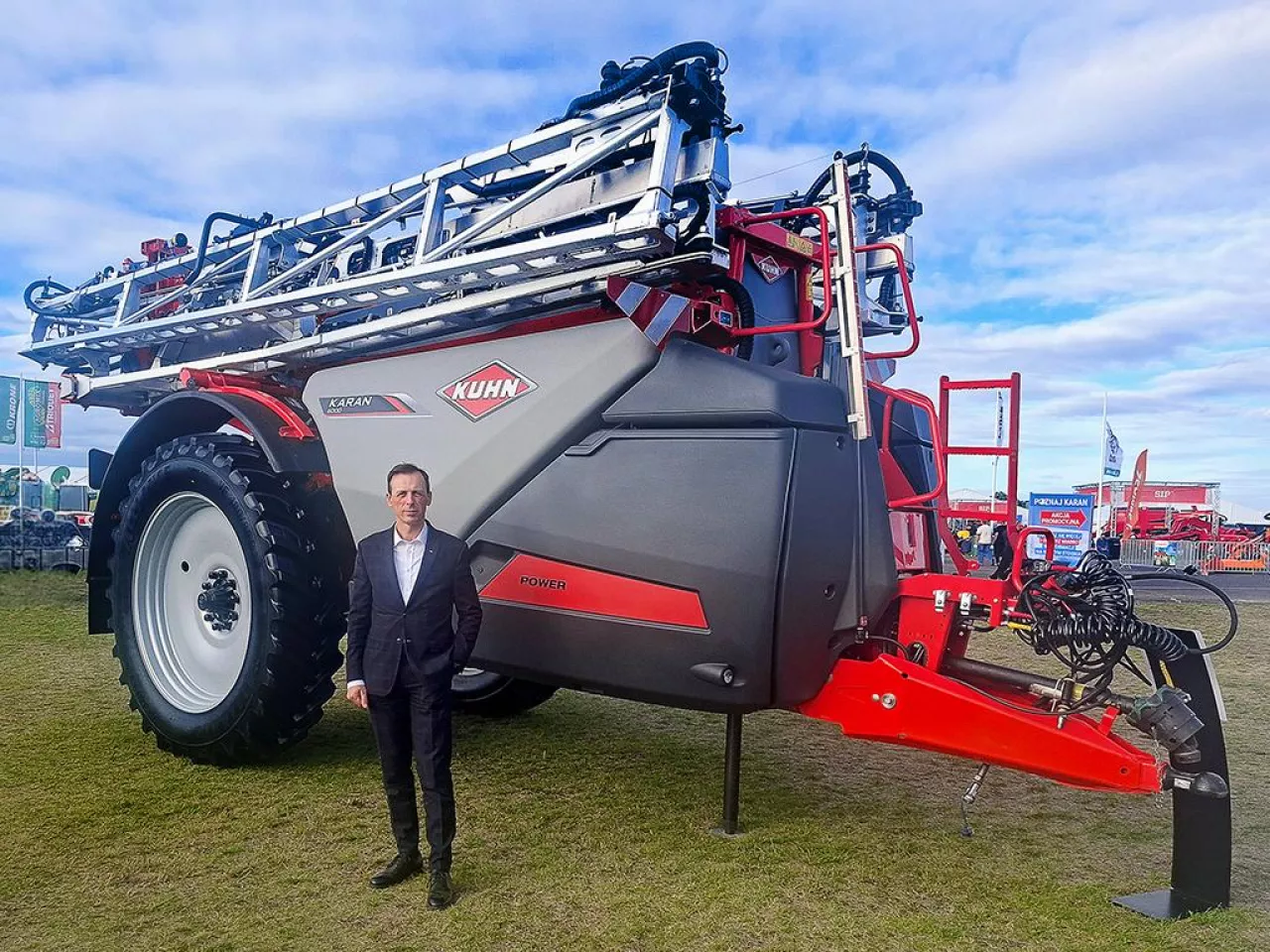 Artur Szymczak z firmy KUHN na tle opryskiwacza podczas Agro show 2026